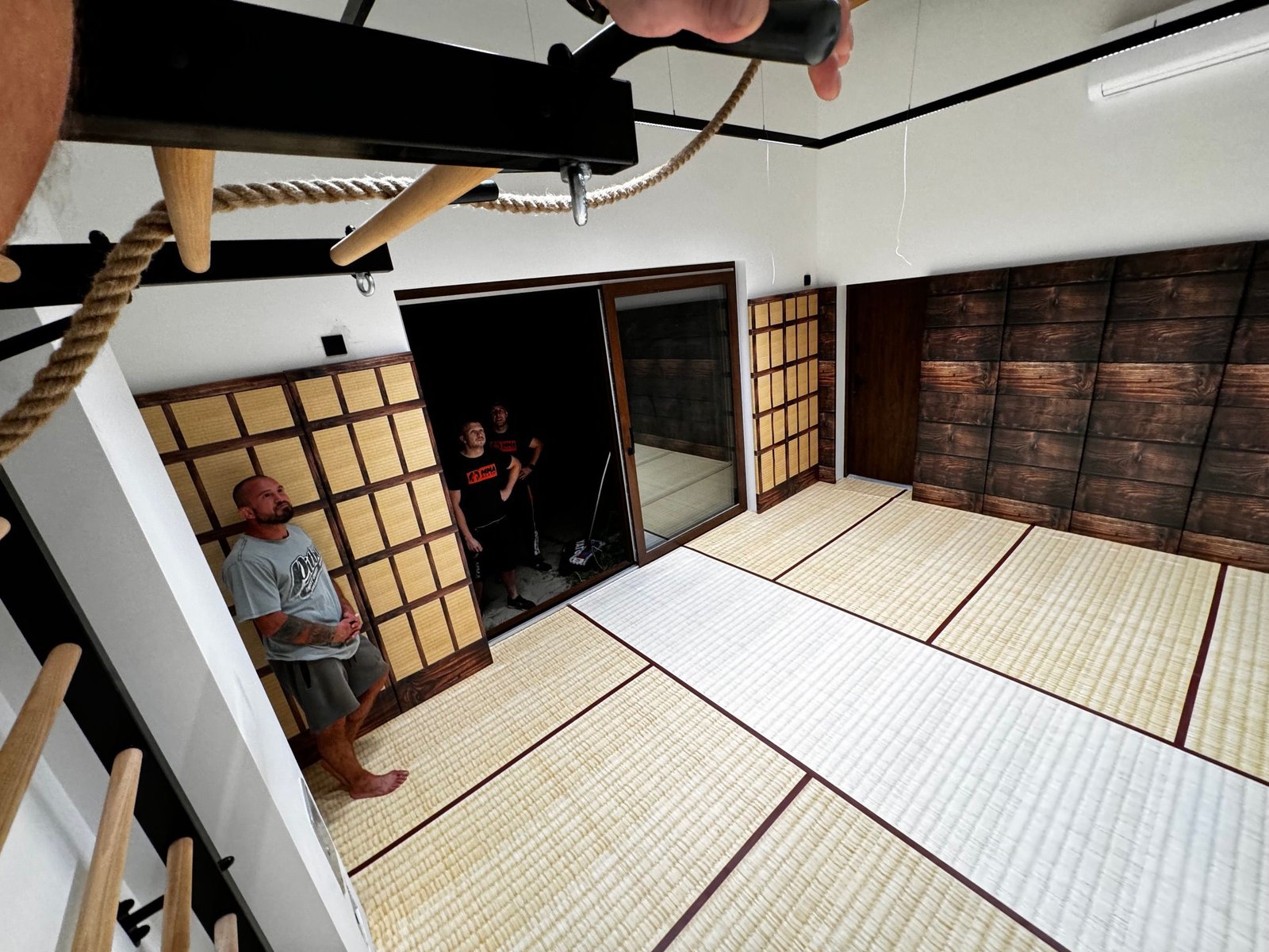 Prywatne dojo z matą imitującą tatami, ścianą w stylu japońskiej pergoli i matami ściennymi z nadrukiem drewna
