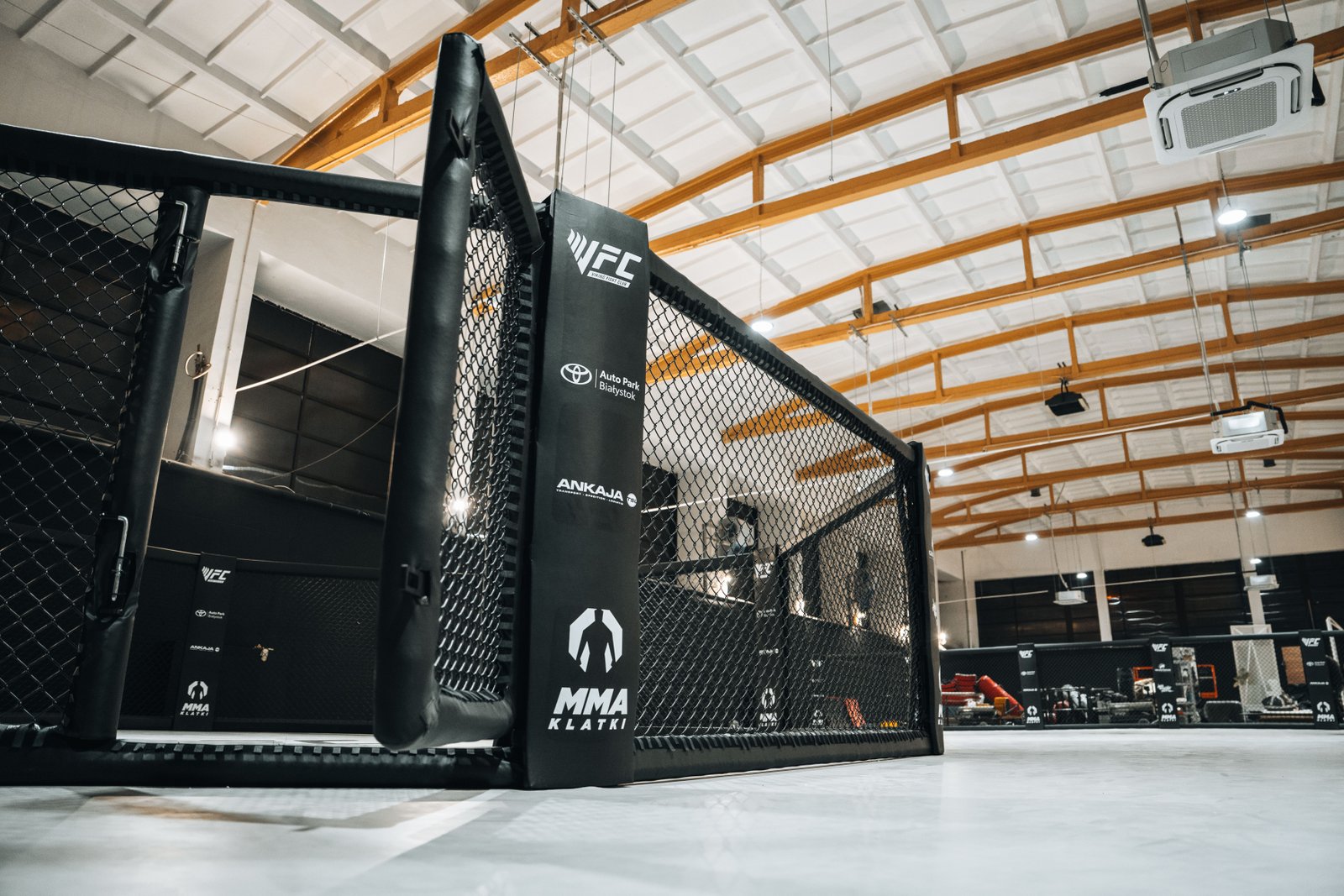 Narożnik klatki MMA z oznaczeniami VFC i MMA Klatki.