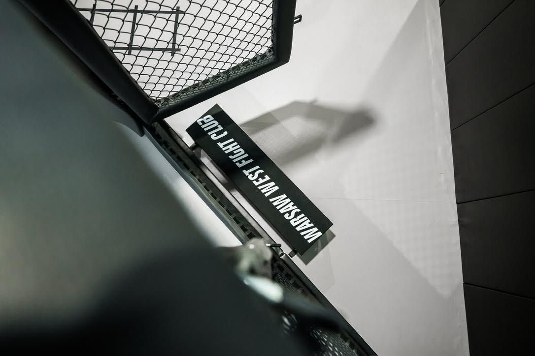 Widok z góry na osłonę słupka ściany z siatki z nazwą klubu, czarna siatka i jasna mata