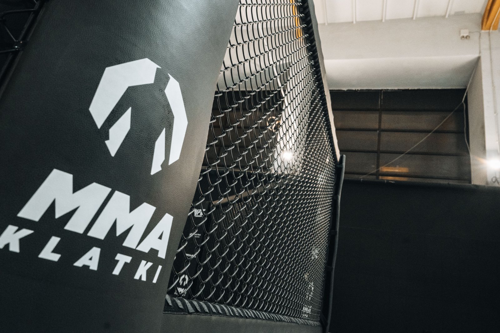 Detal osłony słupa klatki z oznaczeniem MMA Klatki.