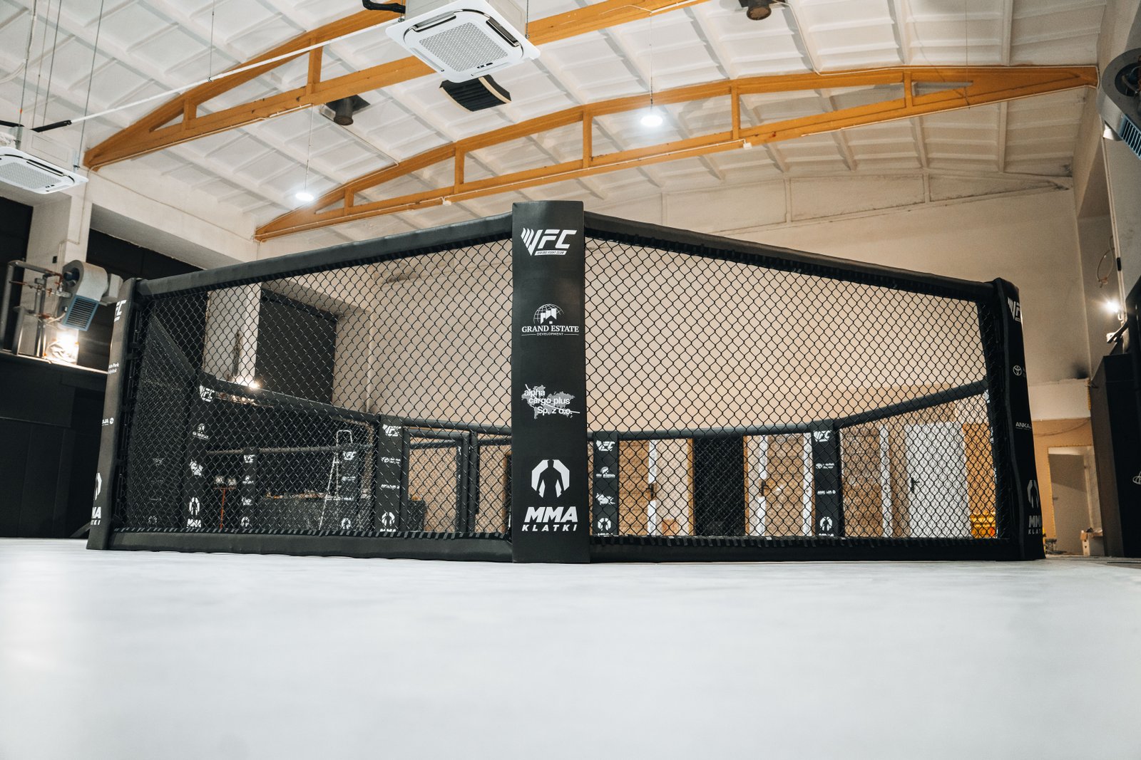 Klatka MMA na tle przestronnej sali treningowej Viking Białystok VFC.