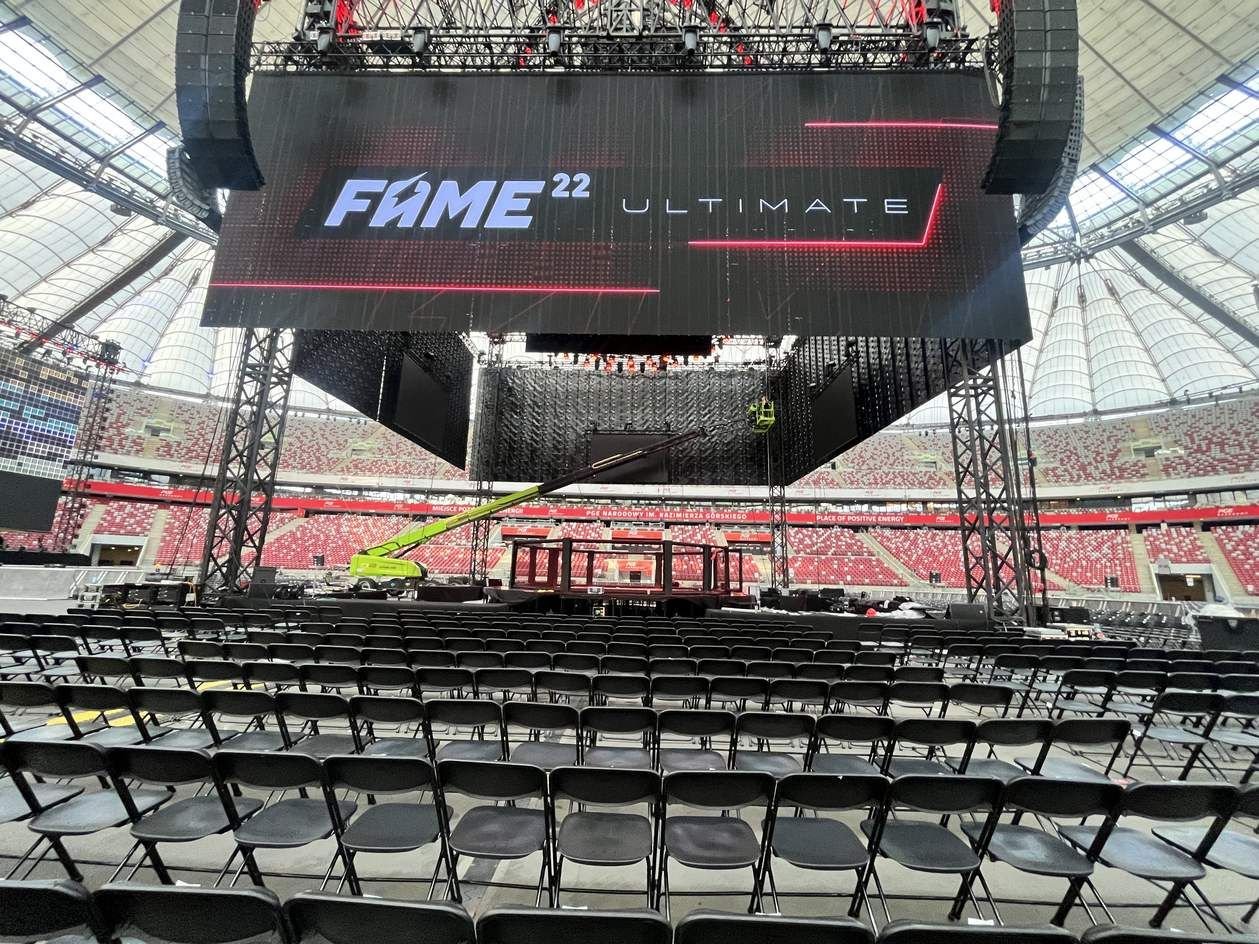 Widok z widowni: główny ekran LED z logo FAME 22 Ultimate nad areną i rzędy krzeseł.