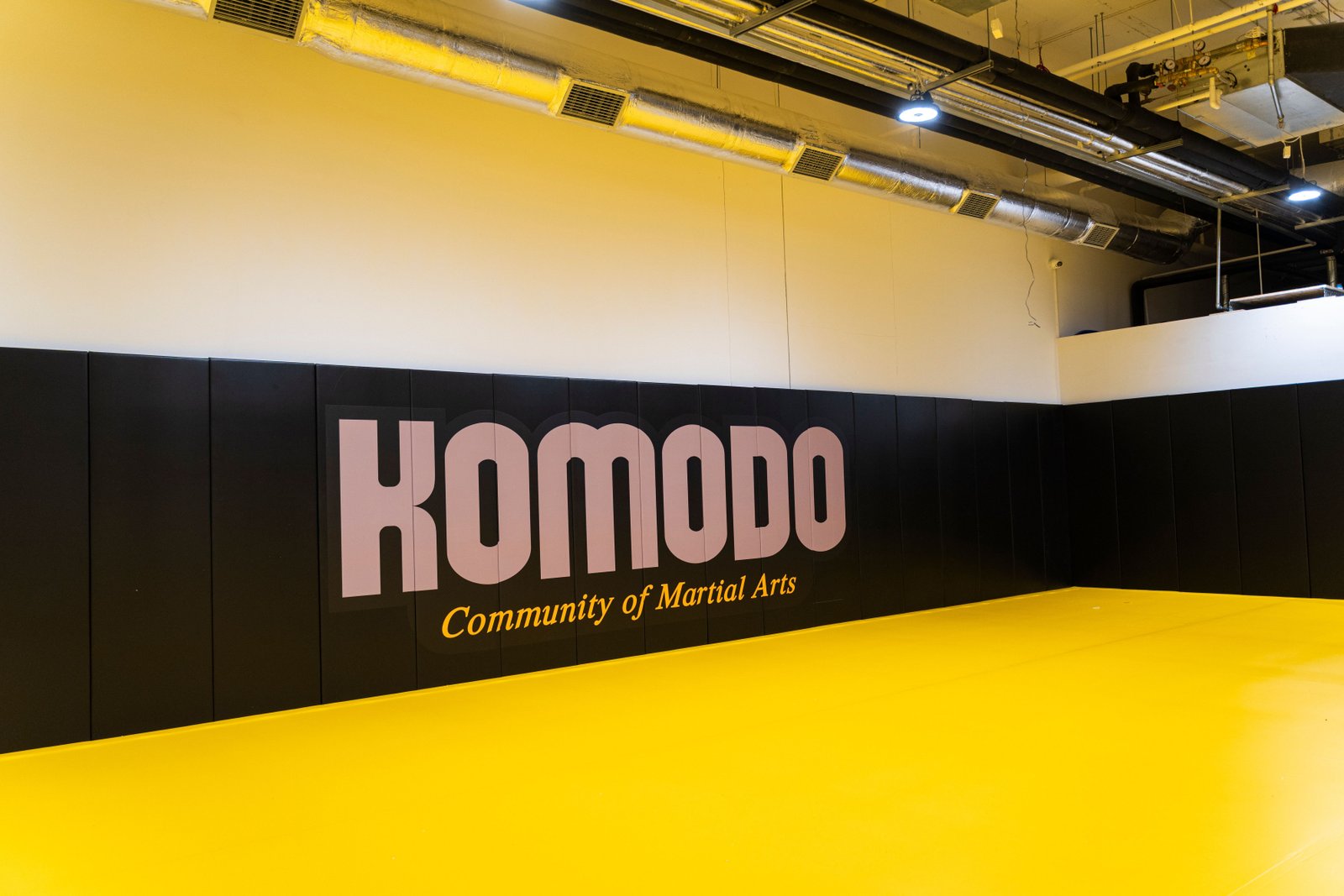 Sala treningowa Komodo Gdańsk z matami podłogowymi i ściennymi.